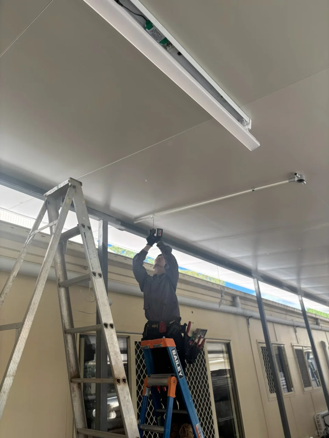 Licensed electrician repairing lighting at a Brisbane temple facility